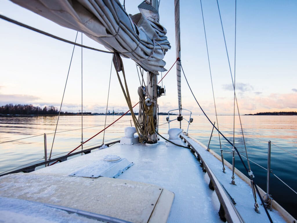 Colorful winter sunset. White yacht sailing, a view from the deck.