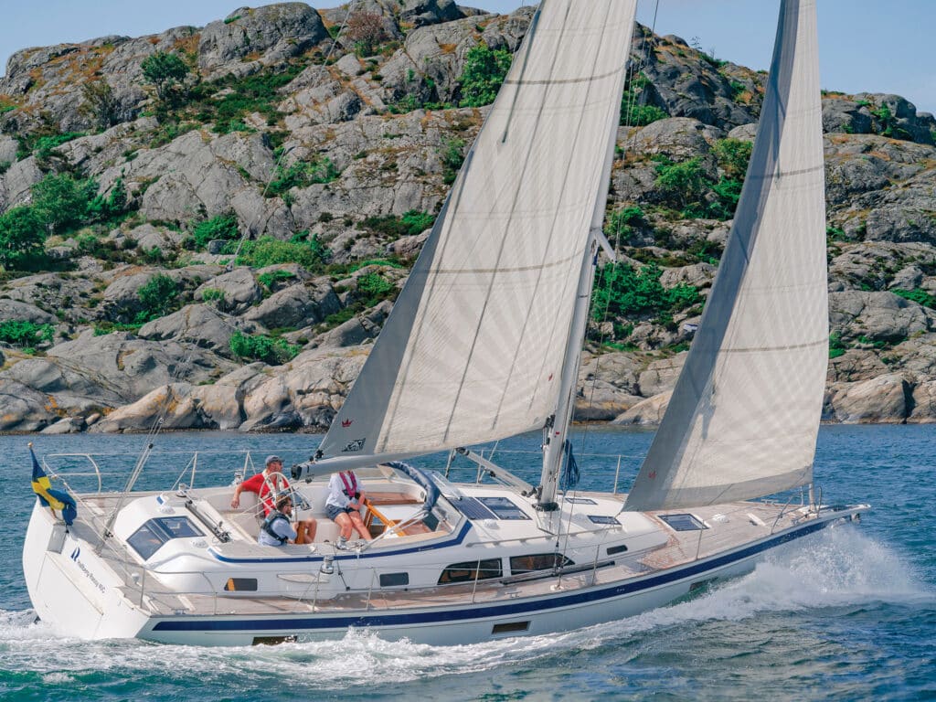 Sailing the Hallberg Rassy 40C. Blue water sailing yacht in sunset.